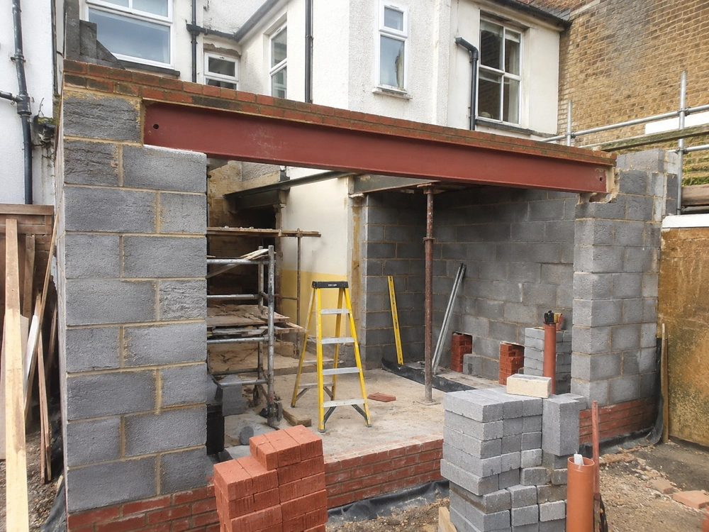 Under-construction single storey rear extension with blockwork walls and exposed steel support beam