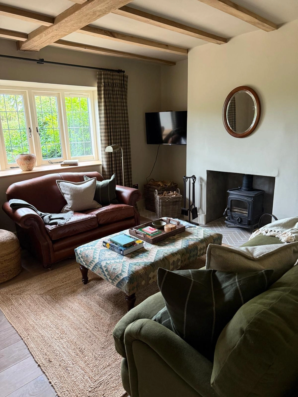Cozy living room with new wood flooring (Wood Flooring), fireplace, leather sofa and green armchair