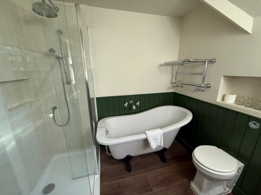 Bathroom Installation: modern bathroom with glass shower enclosure, freestanding bathtub, green wainscoting and wood-effect flooring