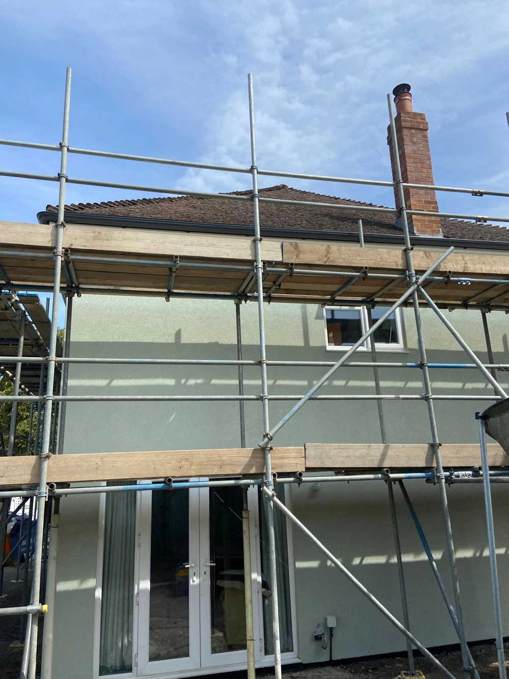 Scaffolding erected around a two-storey house during exterior rendering
