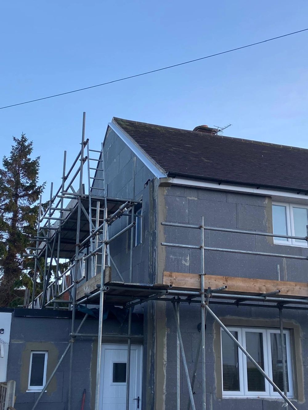 Scaffolding erected on two-storey house during external wall insulation and Rendering