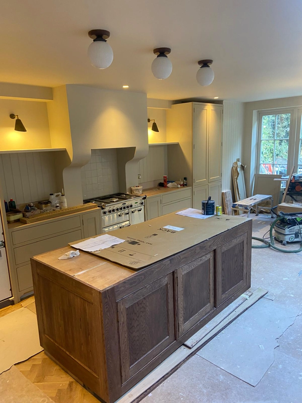 Under renovation kitchen interior with wooden island, wall cabinets and construction tools – Kitchen Renovation