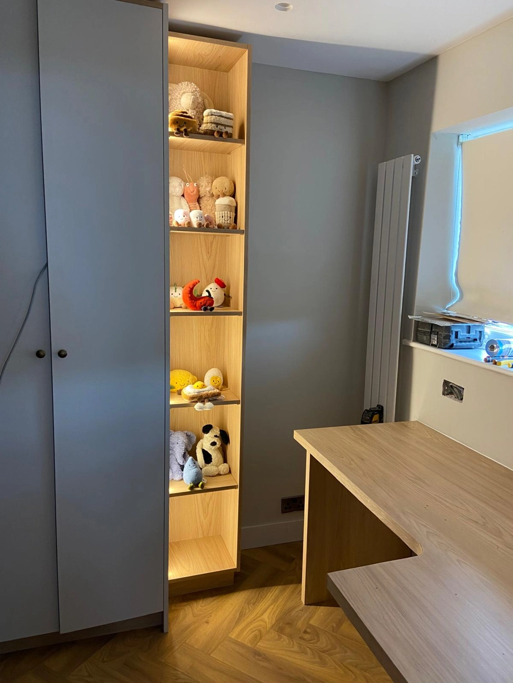 Modern bedroom corner featuring Bespoke furniture shelving with integrated lighting and Wood Flooring