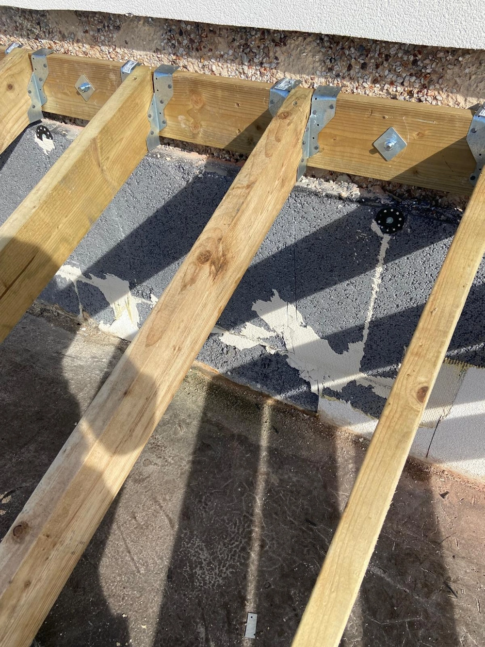 Wood joists fixed to an external wall for subfloor installation, Carpentry service