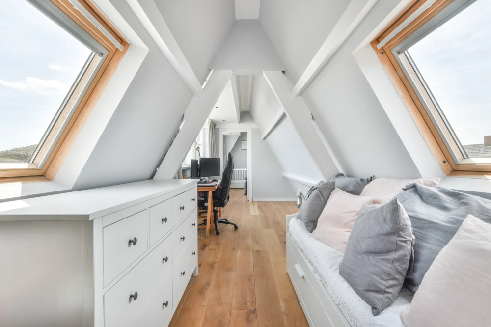 Attic Conversion with wooden flooring, white painted beams, skylight windows, built-in drawers, cushioned seating and a workspace