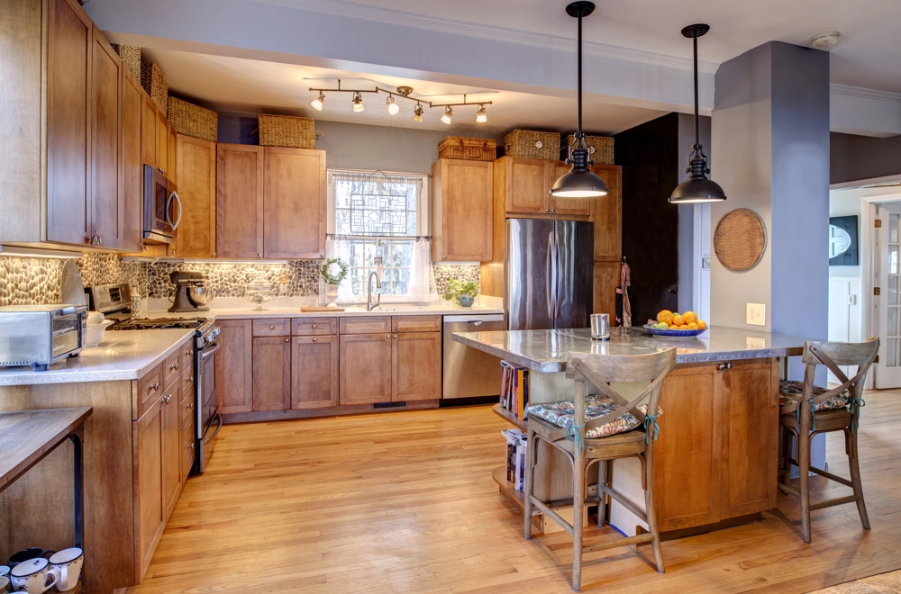 Kitchen Renovation showcasing spacious kitchen with timber cabinets, central island, wood flooring and tiled backsplash