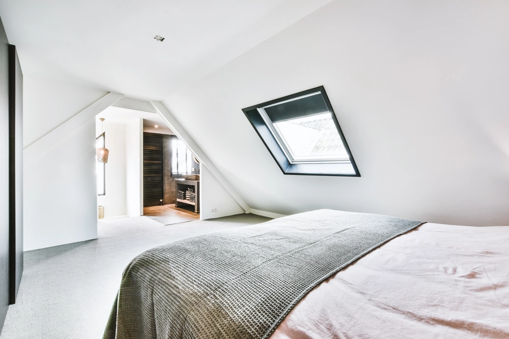 Attic bedroom renovated via Loft Conversion with roof window and en suite bathroom