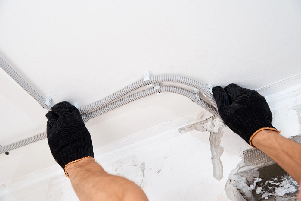 Fitting grey plastic conduit for electrical wiring under ceiling (Electrical Services)