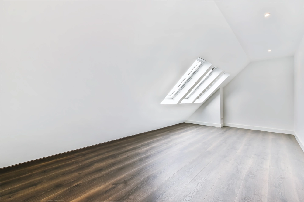 Bright converted attic space with laminate flooring and skylights, showcasing Loft Conversion