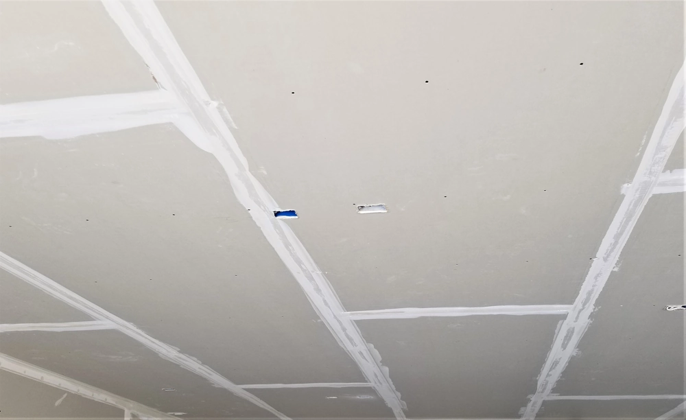 Gypsum board ceiling with taped and plastered joints ready for finishing – Drylining