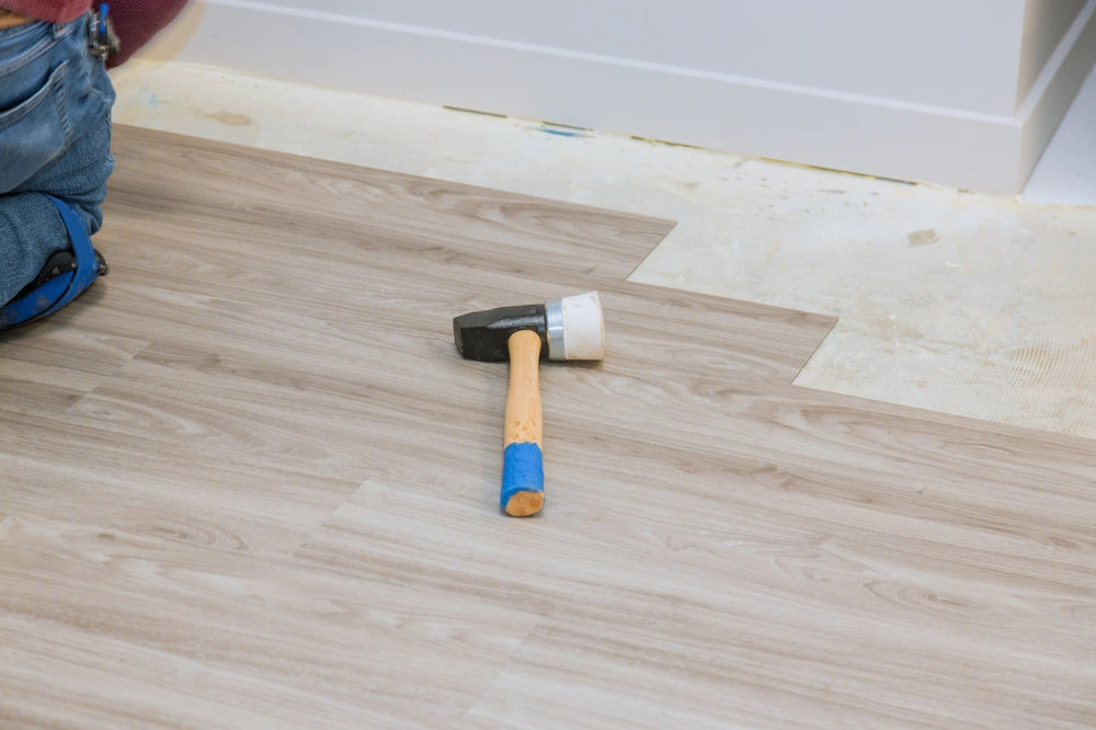 Rubber mallet on newly installed laminate planks during Flooring Installation
