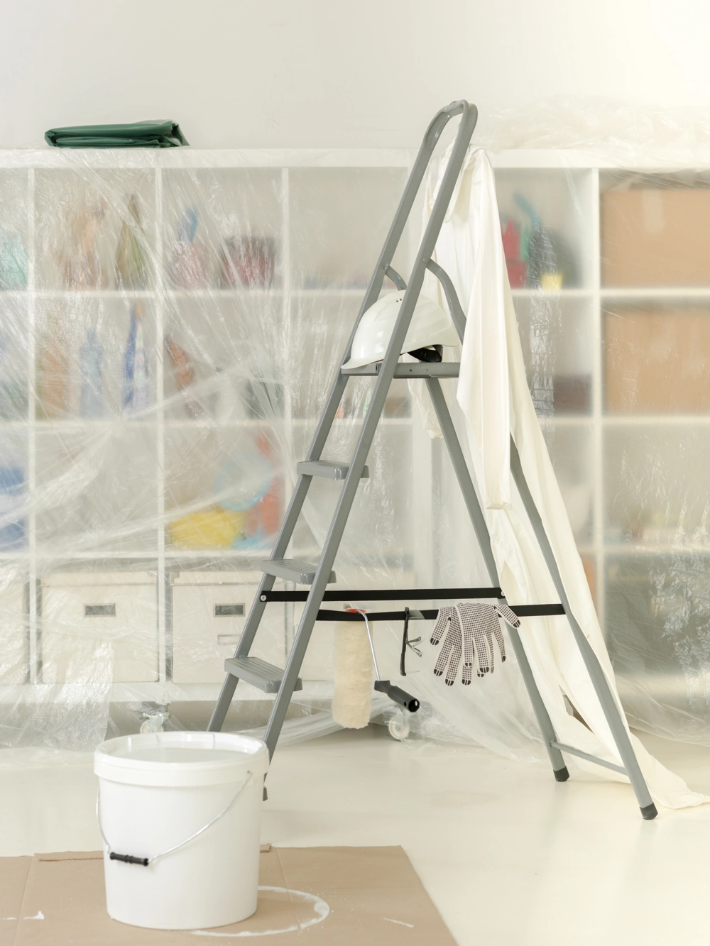 Stepladder with paint bucket, roller and protective sheeting staging Interior Painting work