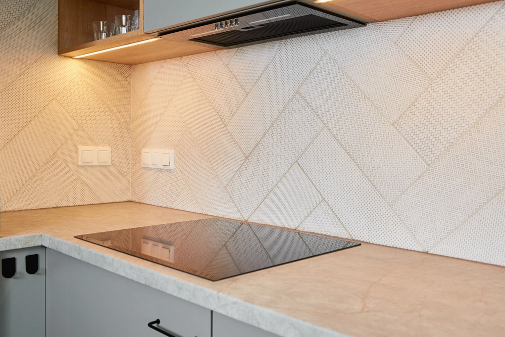 Modern kitchen with built-in induction hob, light stone countertop and geometric tiled backsplash, Kitchen Installation