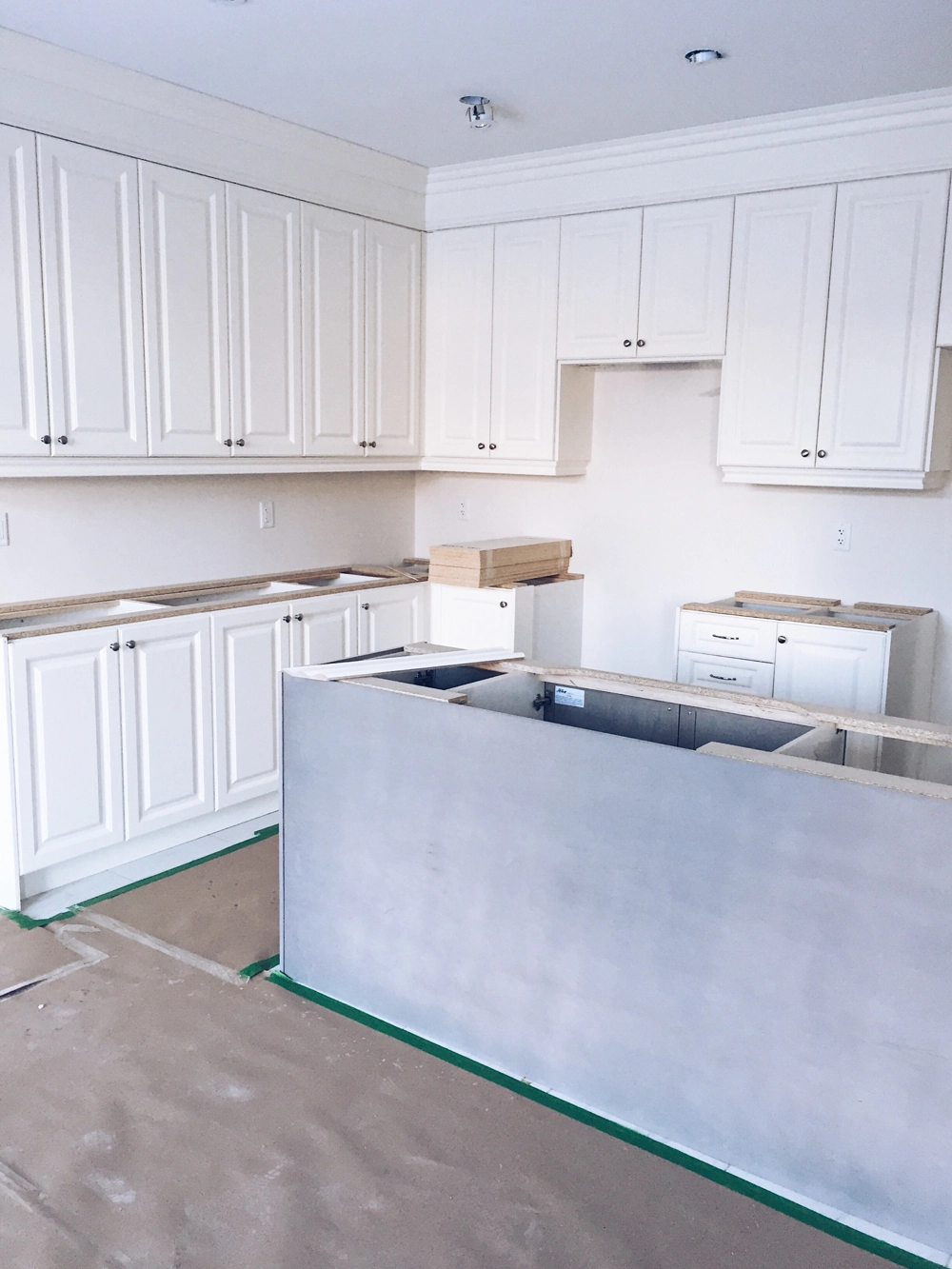 Under-construction kitchen with white cabinets and island base for Kitchen Installation