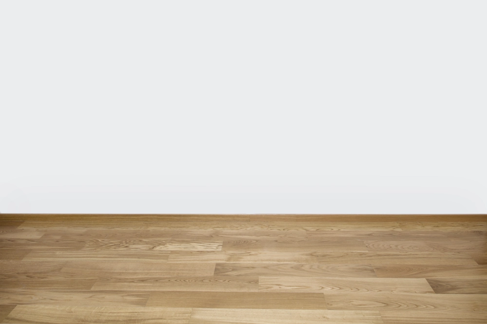 Empty room with new wood flooring and white plastered wall showcasing Wood Flooring